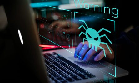 Une main s'apprête à cliquer sur un ordinateur portable affichant une alerte de sécurité numérique "Warning" et une icône d'araignée malveillante, nécessitant l'intervention d'un dépanneur informatique